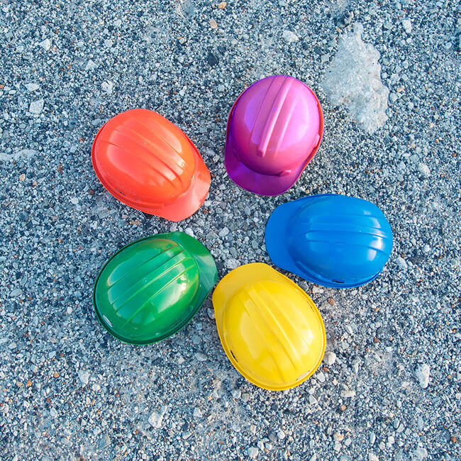 Multi-colored hard hats forming a circle on the ground