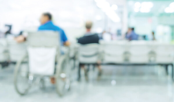 Blurred image of people in wheelchairs in a clinic